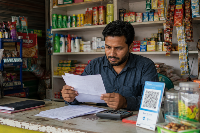 Small business owner in Bangladesh reviewing loan documents without collateral
