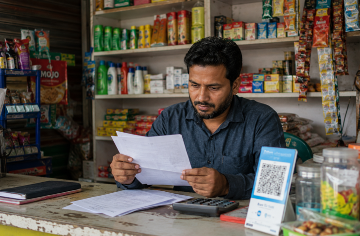 Small business owner in Bangladesh reviewing loan documents without collateral